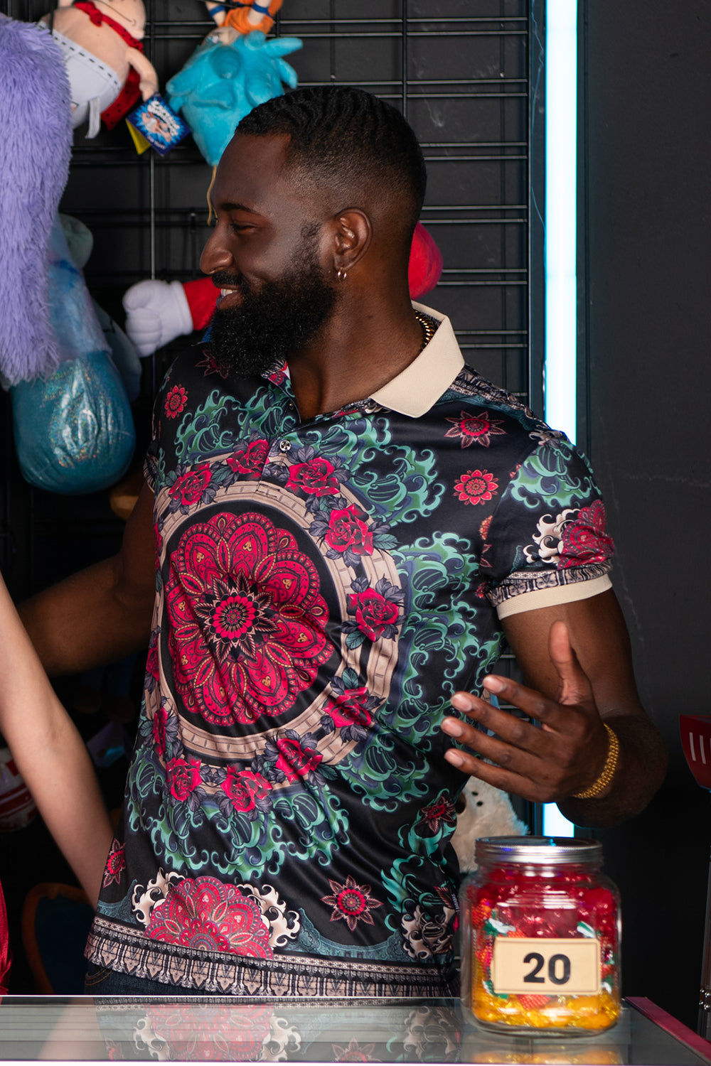 Men wearing patterned polos and smart casual wear at rooftop venue during golden hour